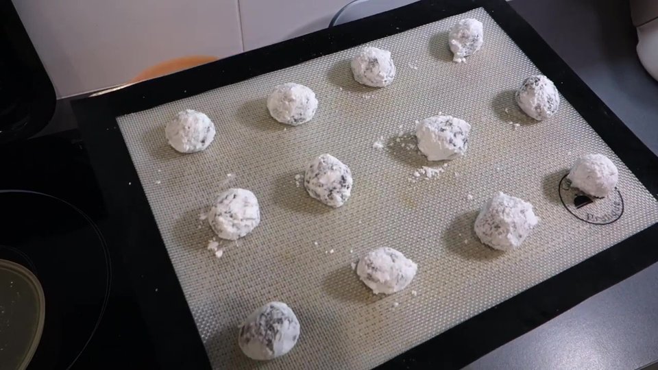 Craquelés au chocolat crus enrobés de sucre glace avant cuisson.