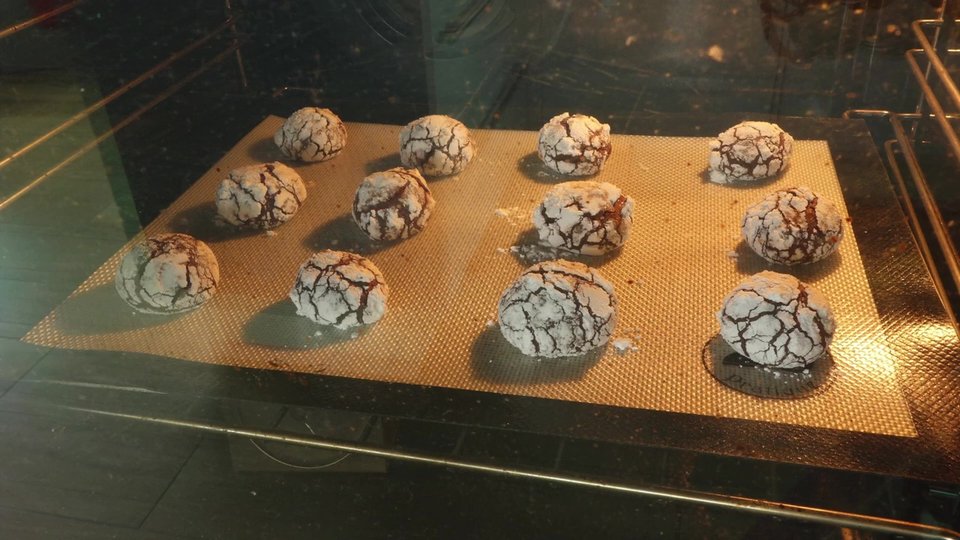 Biscuits craquelés au chocolat en cuisson avec effet fissuré.