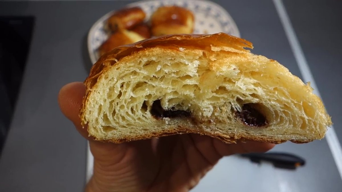 Intérieur d’un pain au chocolat maison bien feuilleté avec chocolat fondant.