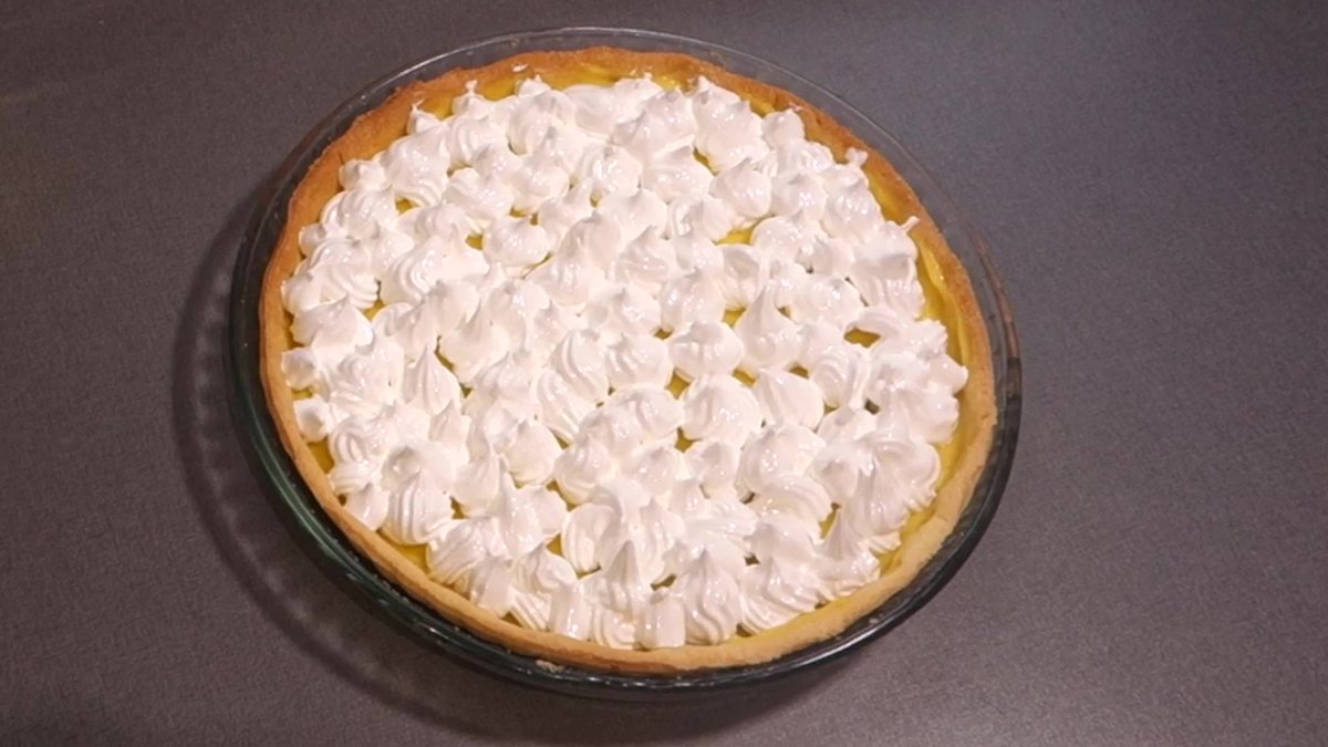 Tarte recouverte de meringue italienne pochée uniformément, prête à être dorée.